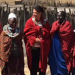 Audrey Bely en voyage, entourée de femmes en tenue traditionnelle