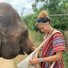 Audrey Bely en voyage, souriante à côté d'un éléphant
